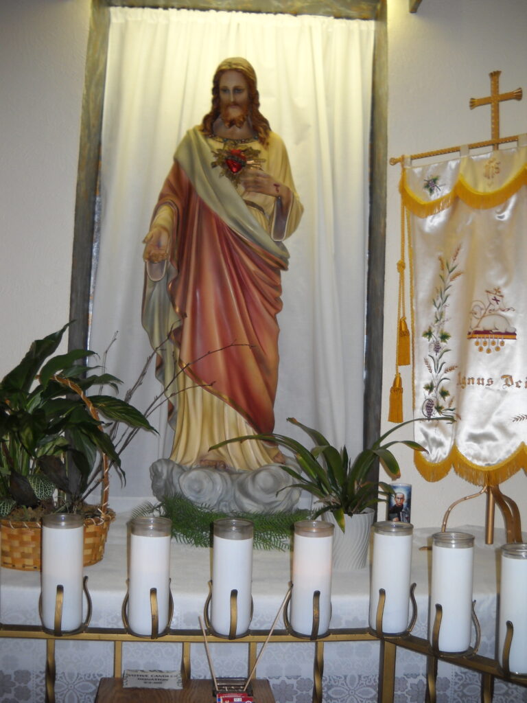 A statue of Jesus behind a row of candles - pastoral council