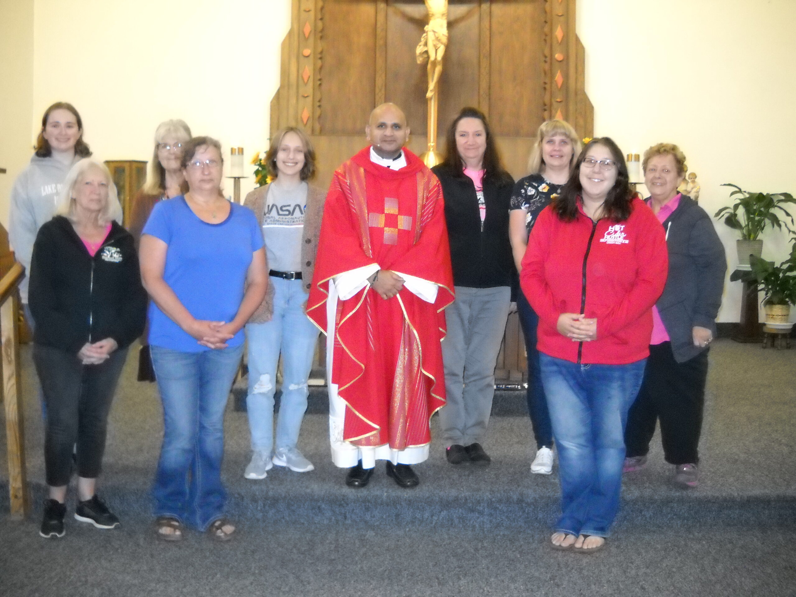 Father Nusi with several women standing in front of the altar